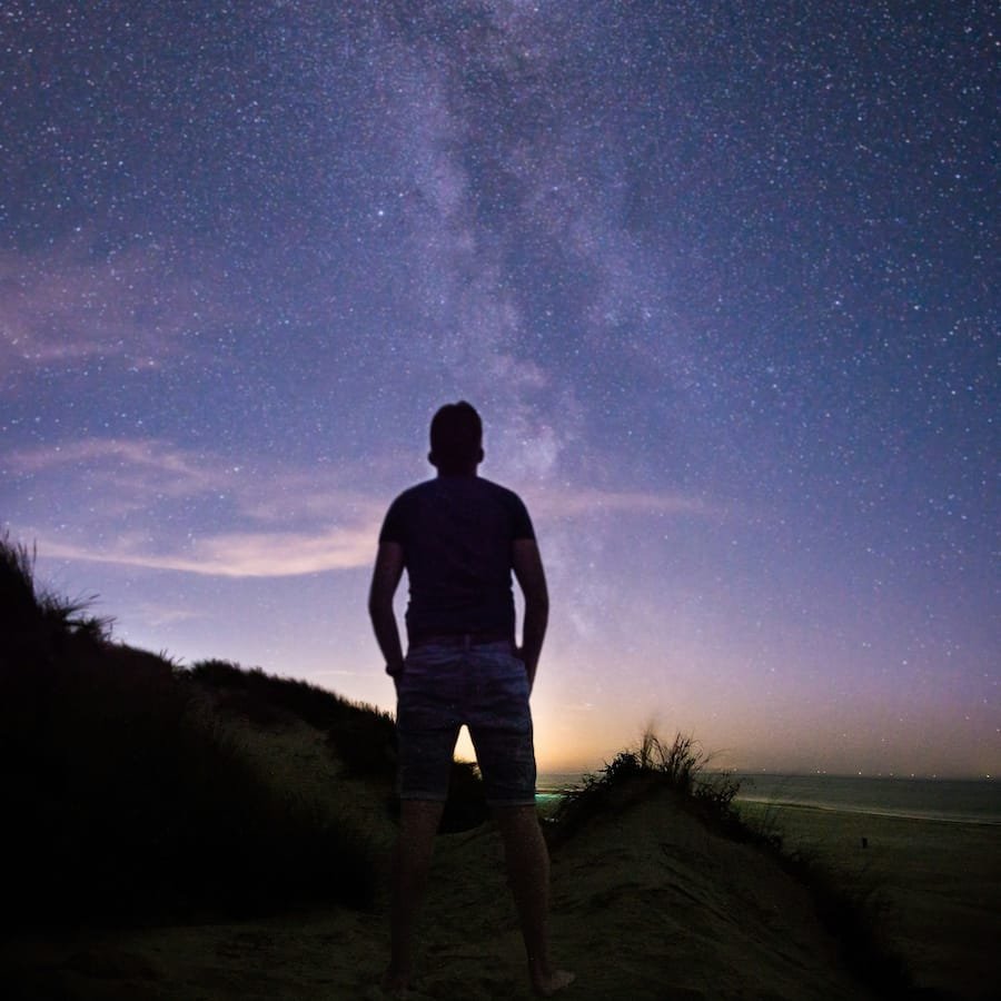 Man looking at starry night sky.