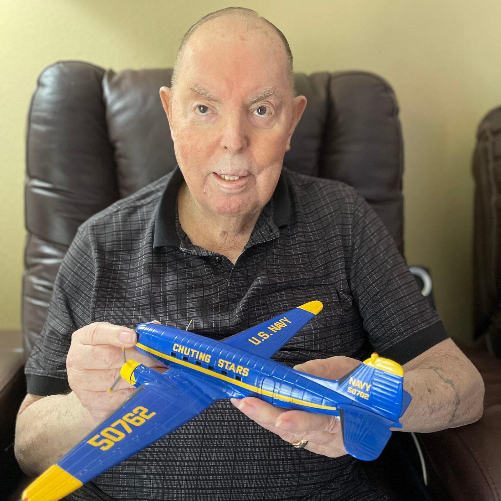 Coy Martin, in his home, holding a model of the Chuting Stars C-117D (R4D-8) Skytrain