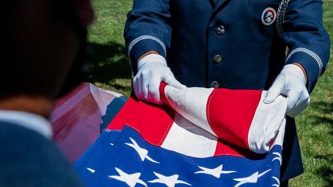Military ceremonial folding of the American flag.