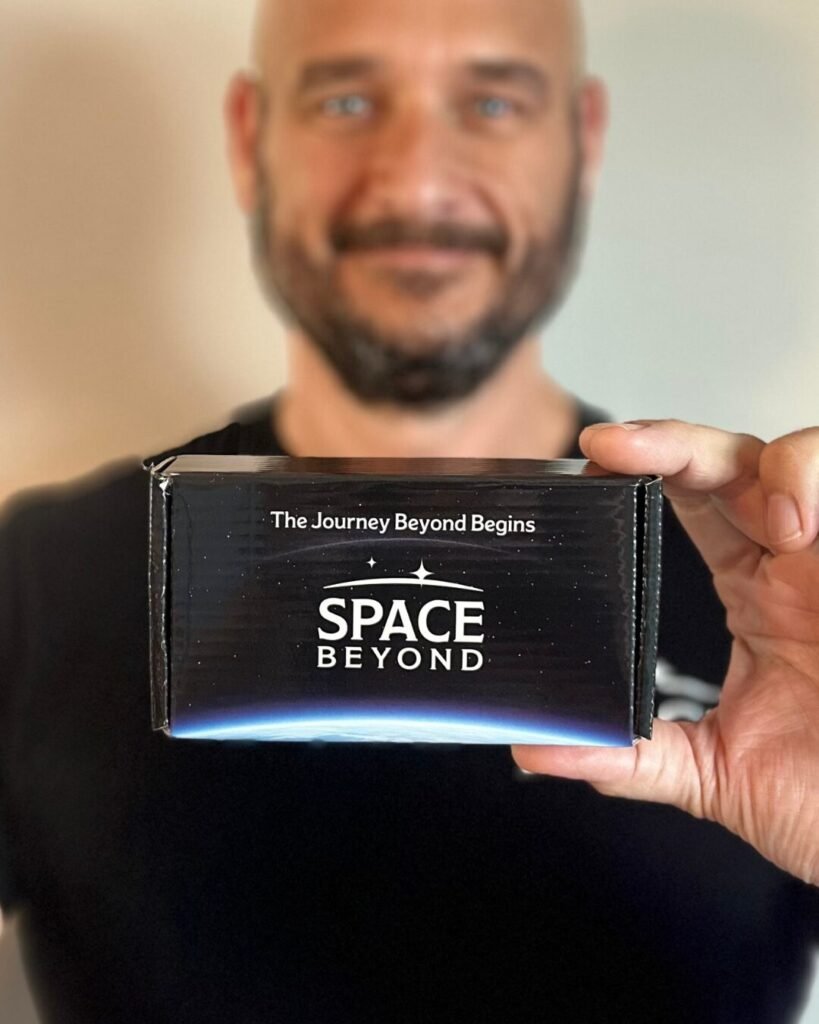 Ryan Mitchell, founder of Space Beyond, holding the Ashes to Space collection kit, with the box in sharp focus in the foreground